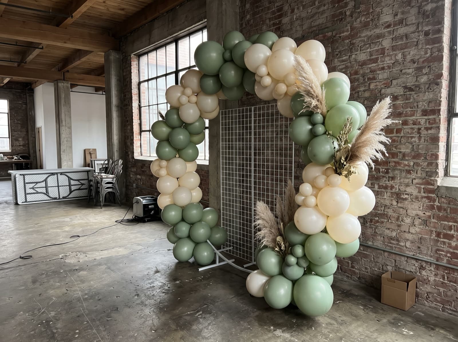 Round balloon arch in sage and ivory framing a photo spot